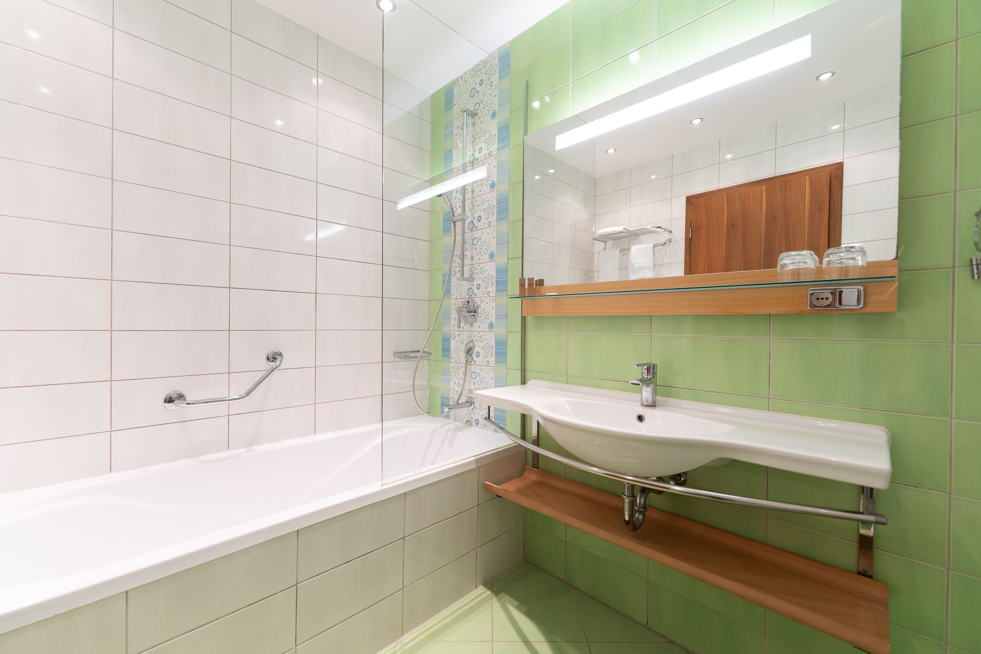 A modern bathroom with a bathtub, a sink, and a mirror.