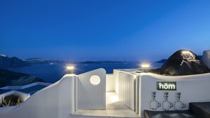 A hotel entrance with a view of the sea and a mountain.