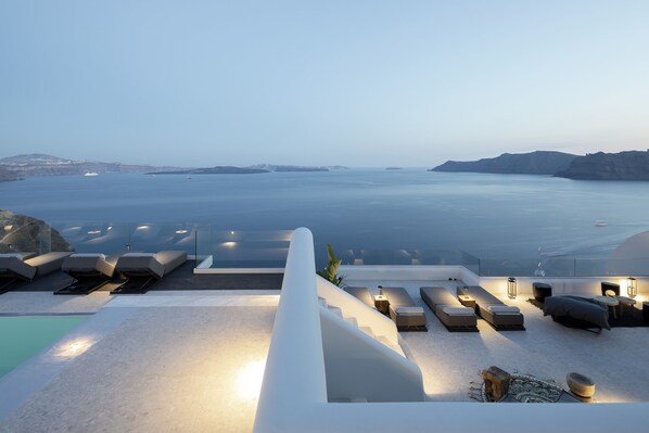 Terraza en la azotea con tumbonas y piscina con vistas al mar.