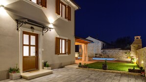 A two-story house with a stone facade, a wooden door, and a swimming pool in the backyard. - Romantic Istrian Villa Nima with private pool (Glavani)
