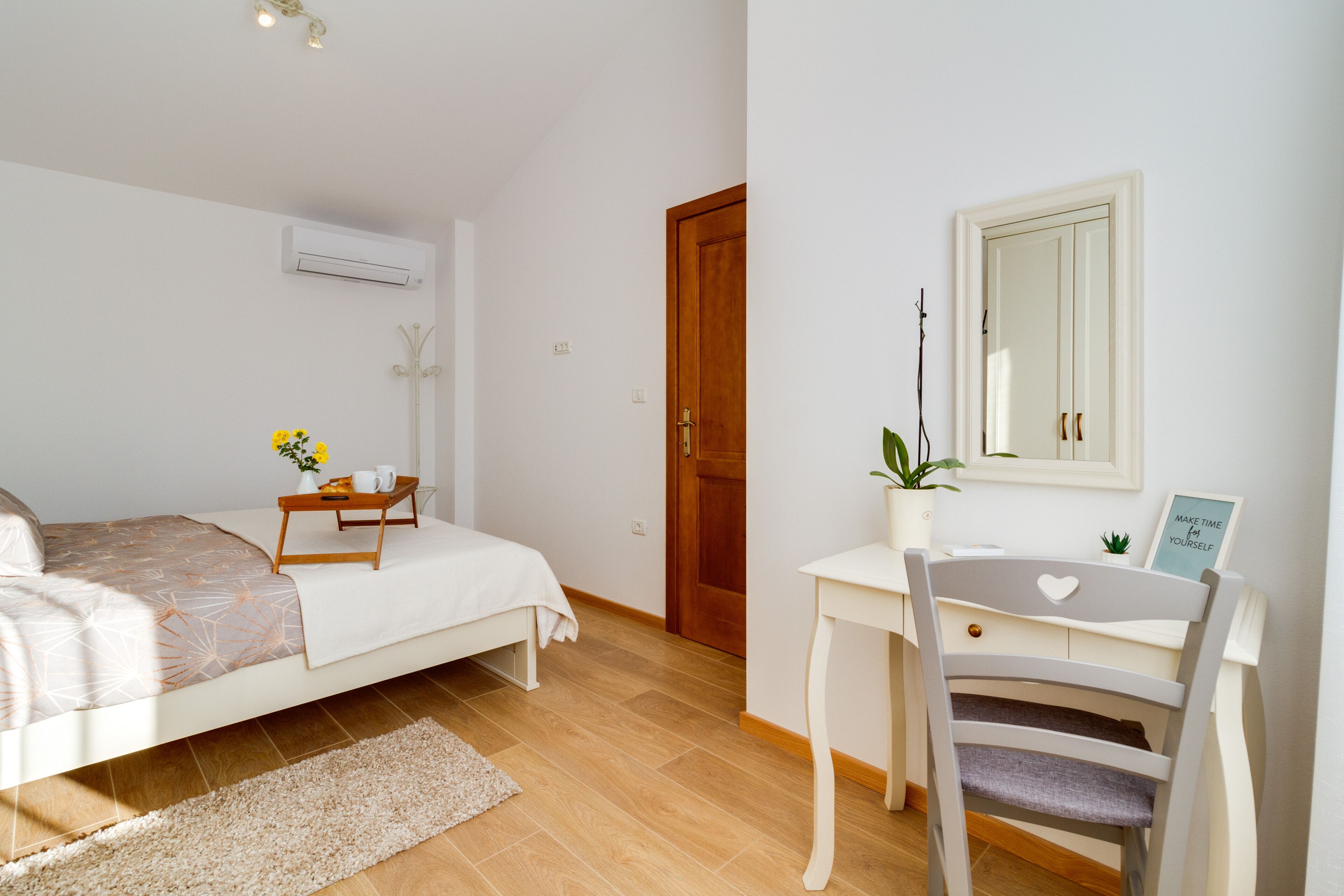 A bedroom with a bed, bedside table, and a desk with a chair.