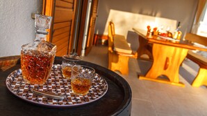 A bar area with a wooden table, chairs, and a bottle of whiskey on a tray. - Romantic Istrian Villa Nima with private pool (Glavani)
