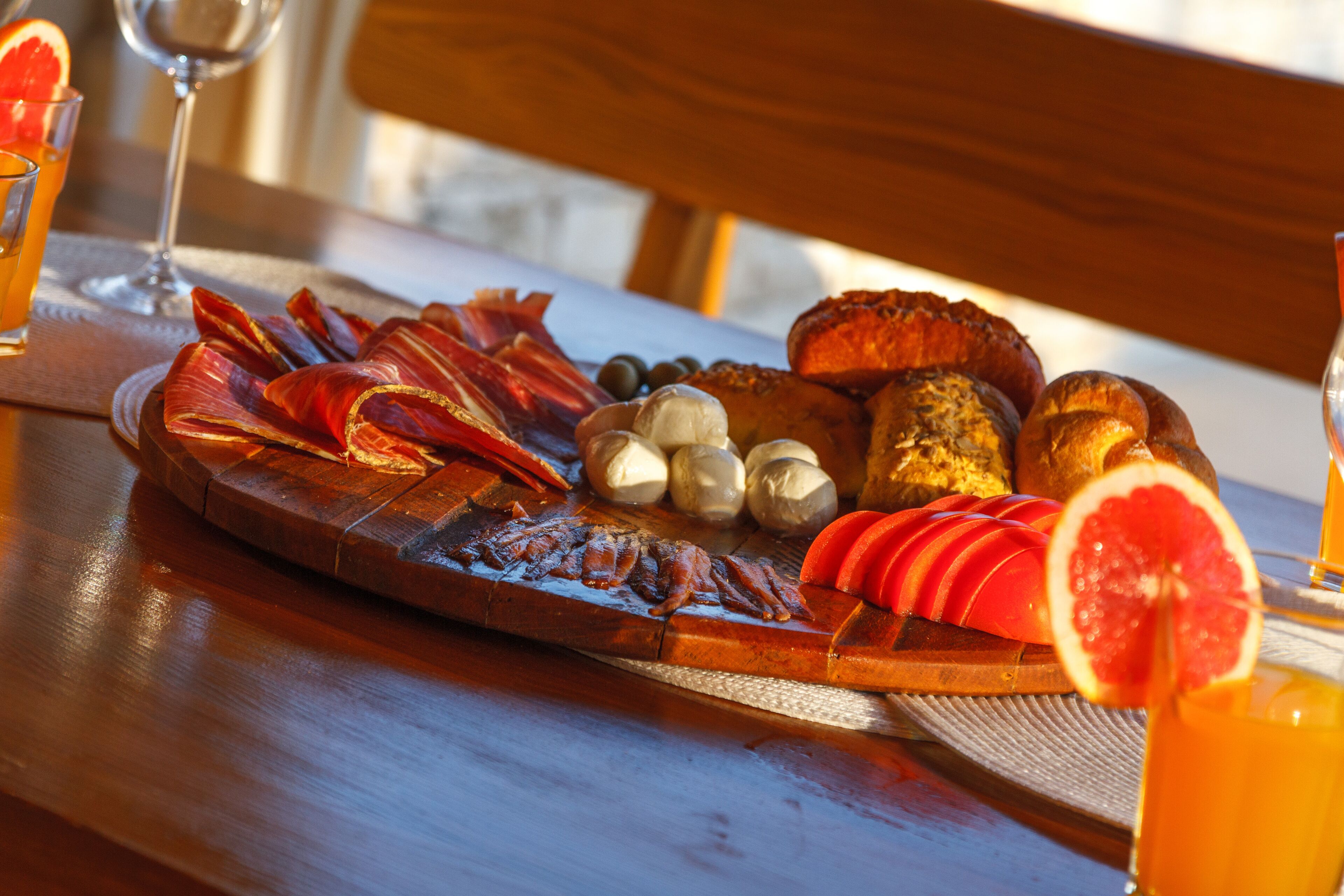 A breakfast tray with various foods and drinks on a wooden table.