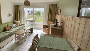 A cozy living room with a sofa, a dining table, and a TV. - House (2Ch) with covered swimming pool Pornichet La Baule (Pornichet)