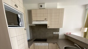 A compact kitchen with light-colored cabinetry, a built-in microwave, a dishwasher, and a sink with a faucet. - House (2Ch) with covered swimming pool Pornichet La Baule (Pornichet)