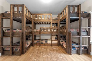 Dormitorio con literas de madera y ropa de cama escocesa.