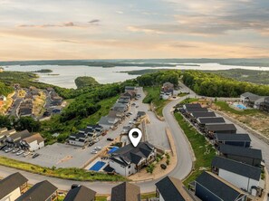 A residential area with houses, a swimming pool, and a view of a lake.
