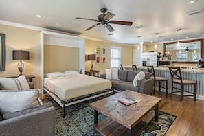 A modern hotel room with a bed, sofa, and coffee table.