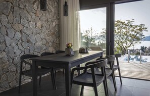 Un espace repas moderne avec un mur en pierre, une table en bois et des chaises.