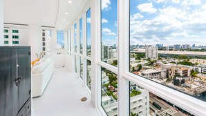 A modern hotel room with large windows, a white sofa, and a view of the cityscape. - Oceanview Private Condo at The Setai -190102 (Miami Beach)