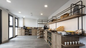 A modern kitchen with wooden cabinets, a coffee machine, and shelves with kitchenware. - Petit Palace Vargas (Seville)