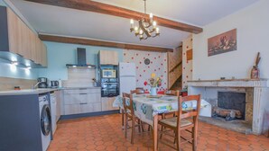 A kitchen with a dining area, a washing machine, a microwave, and a fireplace.