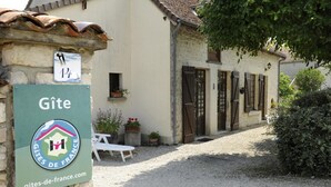A stone building with a sign reading "Gîte" and a website address.