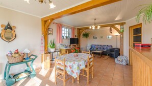 A cozy living room with a dining area, wooden beams, a television, and a sofa. - Le Nid - Rouilly Sacey (ROUILLY SACEY)