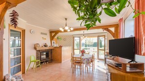 A cozy kitchen with a fireplace, dining table, and a TV. - Le Nid - Rouilly Sacey (ROUILLY SACEY)
