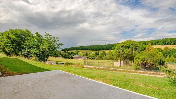 Ländliche Landschaft mit einem großen, offenen Feld, einem Gebäude und einem Zaun.