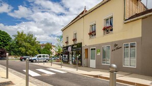 Vista de una calle con un edificio que tiene una cafetería y un bar.