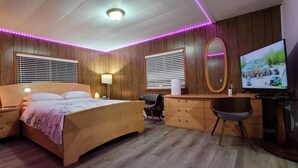 A bedroom with a wooden bed, bedside tables, a desk, a chair, and a TV. - Penguin Cabin The Utmost Family Mt Rainier Getaway (Ashford)