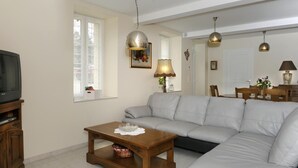 A living room with a grey sofa, wooden coffee table, and pendant lights.