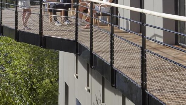 A modern building with a balcony overlooking a lush green landscape. - La Halte Saint Bernard (BAR SUR SEINE)