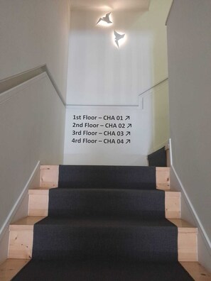 A staircase with a sign indicating floor levels and room numbers. - N Apartments - Chã 101 (Porto)