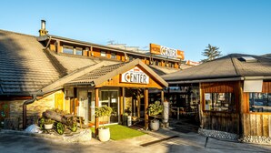 A hotel with a wooden facade, a covered entrance, and a sign reading "Hotel Center." - Hotel Center (Bohinj)