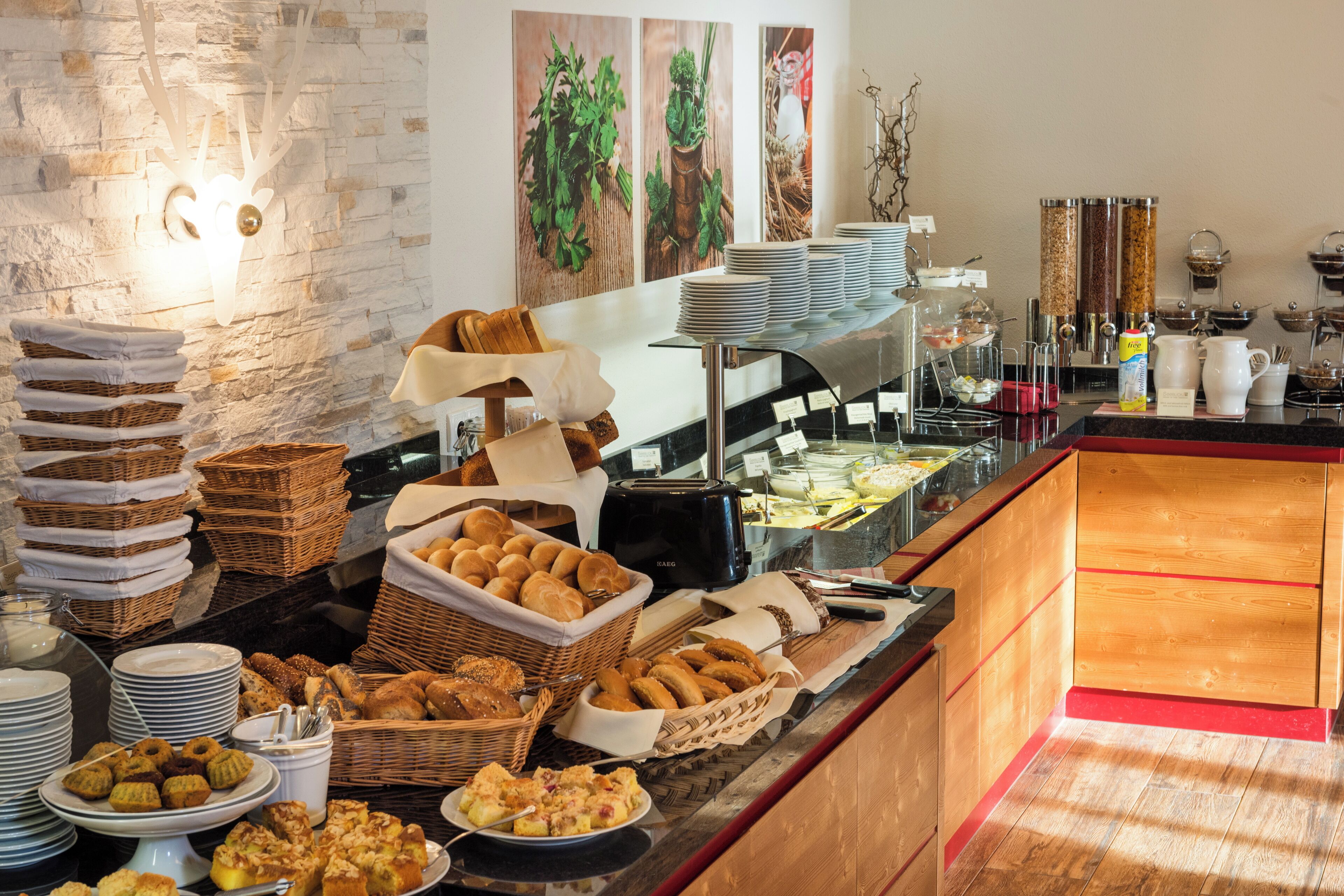 A buffet with various food items, including pastries, breads, and a coffee station.