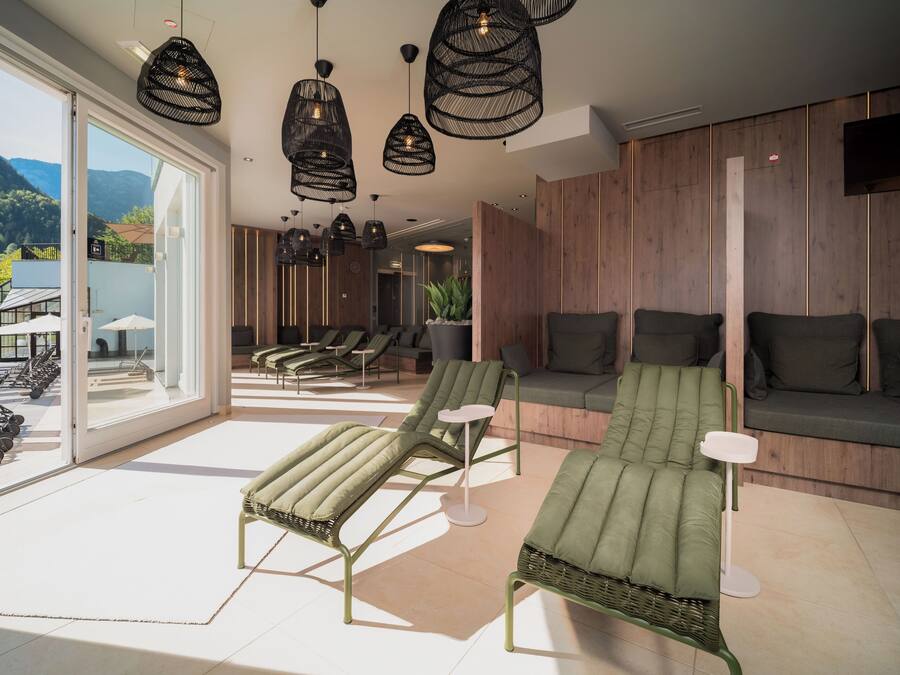 A modern spa area with lounge chairs, a sofa, and pendant lighting.