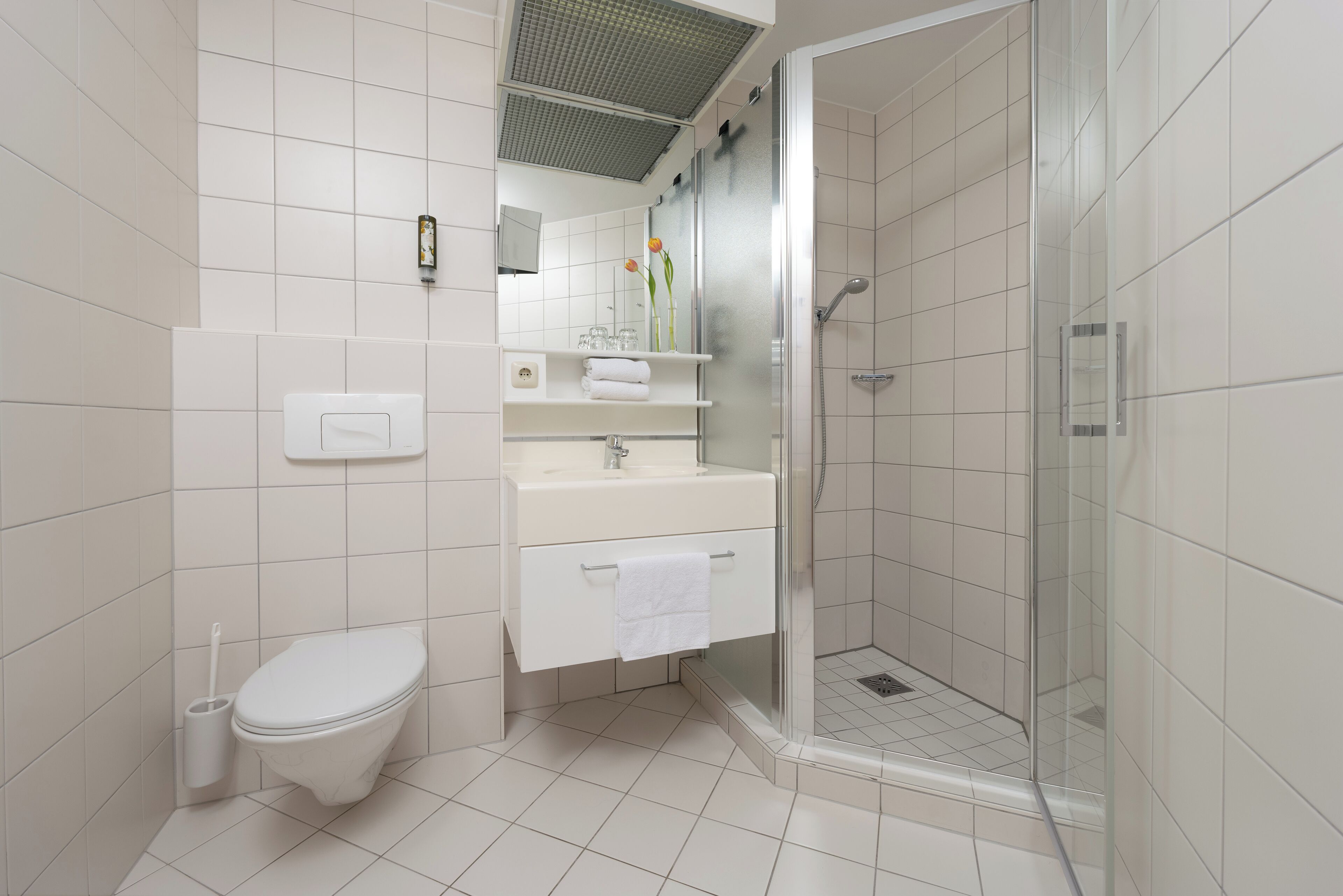 A modern bathroom with a toilet, sink, and shower.