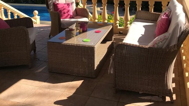 A covered outdoor seating area with wicker furniture and a view of a pool and greenery. - Beautiful Family Villa in Javea, Private pool, Free Wifi, Parking (Xàbia)