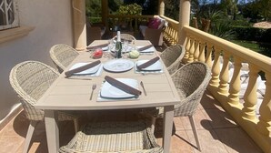 A table set for four with wicker chairs, a yellow balustrade, and a tiled floor. - Beautiful Family Villa in Javea, Private pool, Free Wifi, Parking (Xàbia)