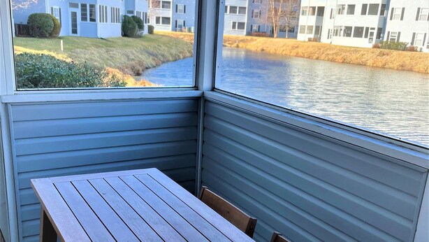 Ein Eckzimmer mit Holztisch und Stühlen, Blick auf einen Fluss und Gebäude im Hintergrund.