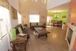 A living room with a sofa, a wooden coffee table, and a dining area with a table and chairs.