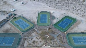An aerial view of a sports complex with multiple tennis courts, surrounded by a fenced area and some vehicles. - Discover Casa Dooley: a spacious 3BR home in San Felipe, perfect for your getaway! (San Felipe)