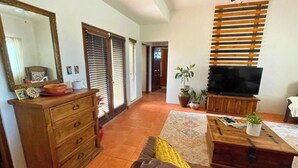 A living room with a sofa, a wooden coffee table, a TV, a dresser, and a mirror. - Discover Casa Dooley: a spacious 3BR home in San Felipe, perfect for your getaway! (San Felipe)