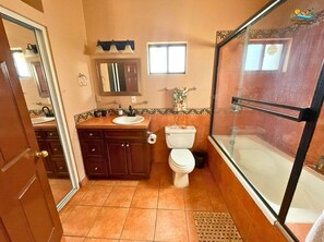 Un baño con inodoro, lavamanos, espejo y cabina de ducha.