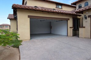 Ein zweistöckiges Haus mit Garage, beige gestrichenen Wänden und einem Ziegeldach.