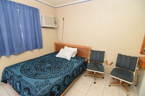 Relax in this cozy space with a single bed, comfortable chairs, and a convenient desk area.