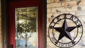 A red door with a glass panel and a Texas state star decoration on the wall. - NEAR BRAZOS COUNTY EXPO CENTER. ENJOY FRESH AIR AND STARRY NIGHTS. (Bryan)