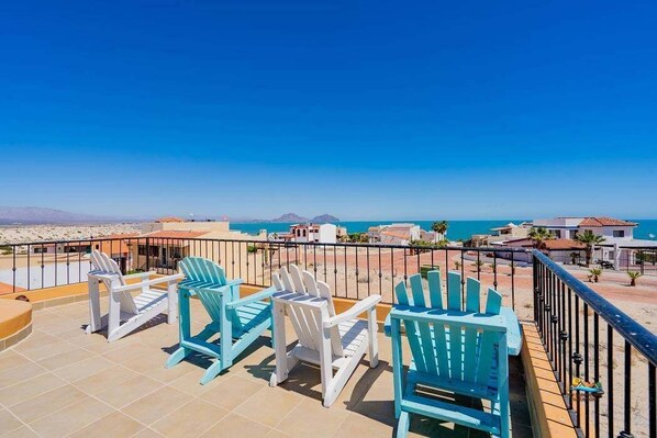 A terrace with chairs and a view of the sea.