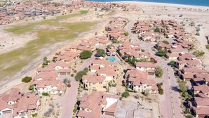 An aerial view of a coastal residential area with houses, roads, and a beach. - Condo 21-1 El Dorado Ranch (San Felipe)