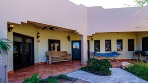 A courtyard with a bench, a hammock, and a small garden area. - Casa Roja, a spacious 3-bedroom home (San Felipe)