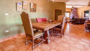A dining area with a wooden table and chairs, a chandelier, and artwork on the wall. - Casa Roja, a spacious 3-bedroom home (San Felipe)