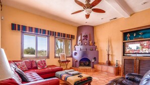 A living room with a fireplace, leather sofas, a television, and a ceiling fan. - Casa Roja, a spacious 3-bedroom home (San Felipe)