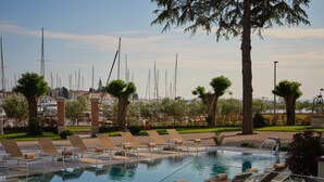 Zona de piscina amb gandules i vistes a velers.