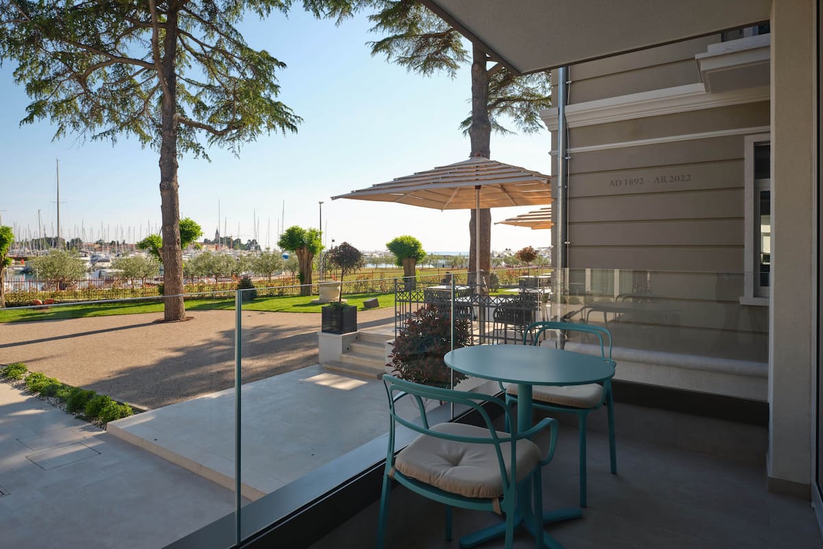 A patio area with outdoor seating, a view of the marina, and a building with a date plaque.