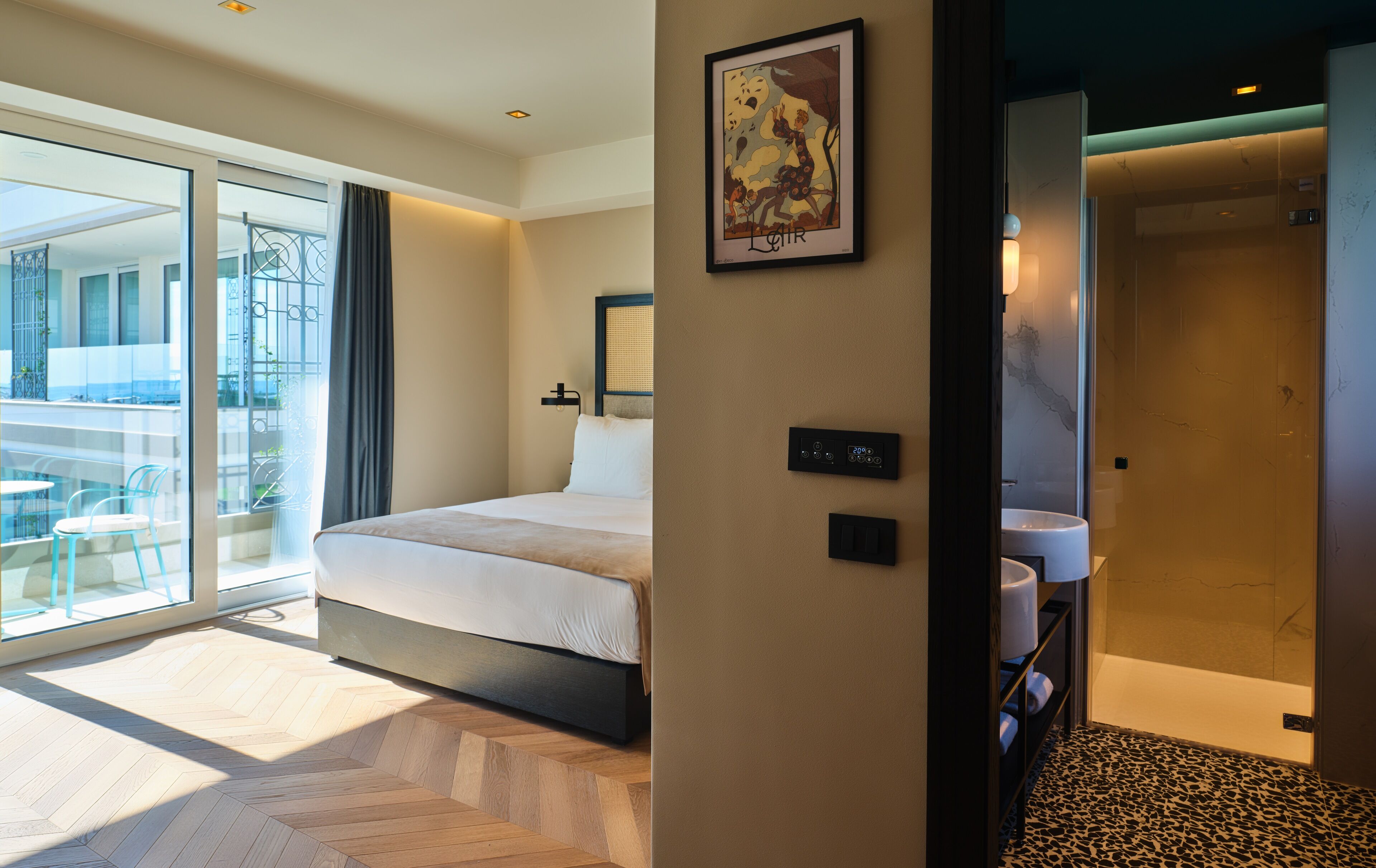 Una habitación de hotel moderna con una cama grande, un termostato digital y vistas al área exterior.