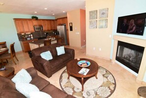 A living room with a brown sofa, a coffee table, and a fireplace.