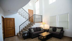 A living room with a staircase, a sofa set, a coffee table, and a lamp. - Condo 37-3 El Dorado Ranch (San Felipe)