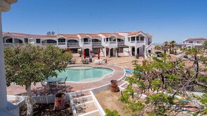 A hotel with a swimming pool, outdoor seating, and a clear view of the surrounding area. - La Hacienda Condo 18 (San Felípe)